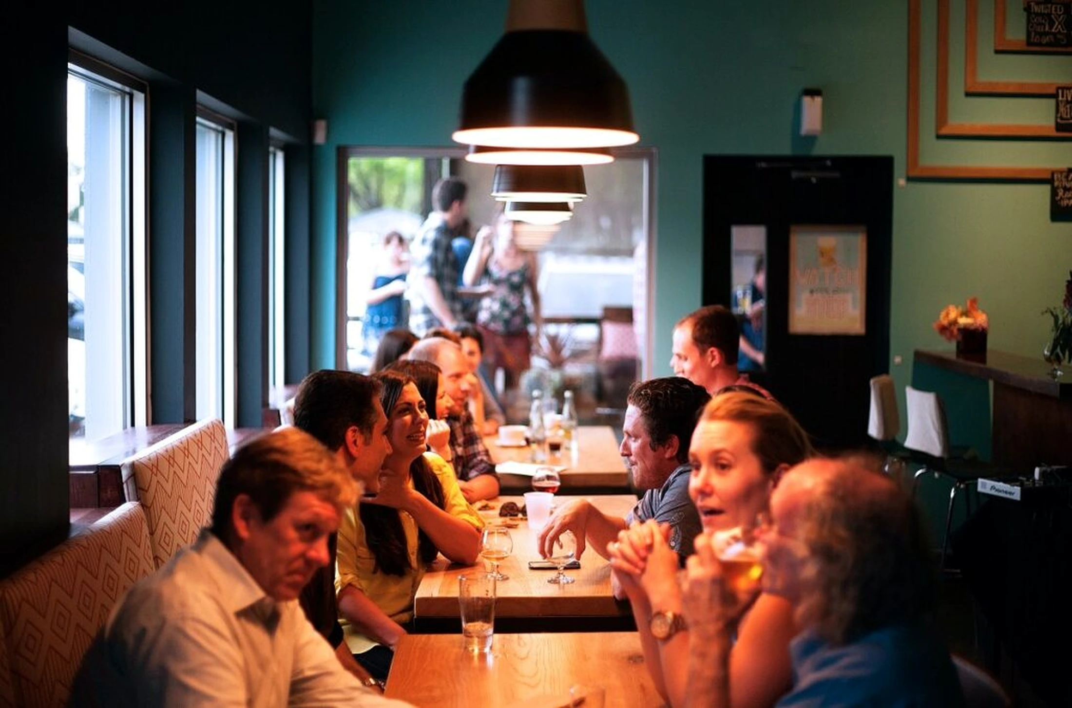 Leden van de VAO in gesprek aan een lange tafel tijdens een borrel